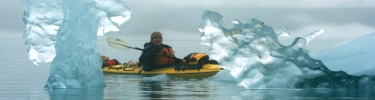 kayaker among icebergs